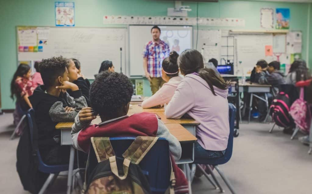 Alunos ouvindo o professor - Benefícios do governo para estudo